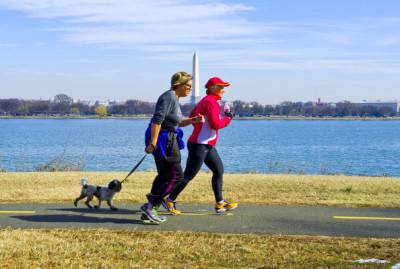 Runners with their dog jog the Mount Vernon Trail, March 8, 2014 near Alexandria, Virginia. Spring-like temperatures arrived in the Washington, DC area soaring into the mid-60sF (17C), giving much needed relief to snow weary residents. AFP PHOTO / Karen BLEIER        (Photo credit should read KAREN BLEIER/AFP/Getty Images)