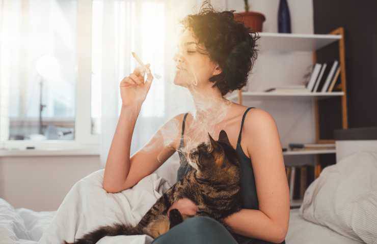 Donna che fuma con gatto vicino