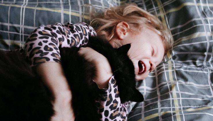 Bambino felice con il gatto nero