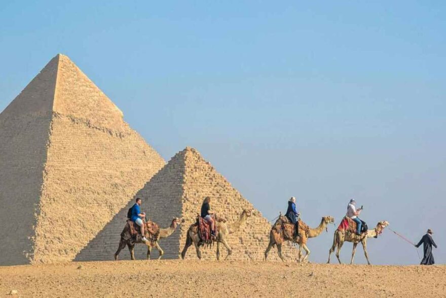 Cammelli con turisti tra le piramidi