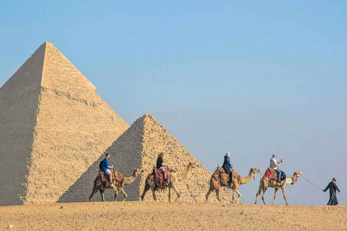 Cammelli con turisti tra le piramidi